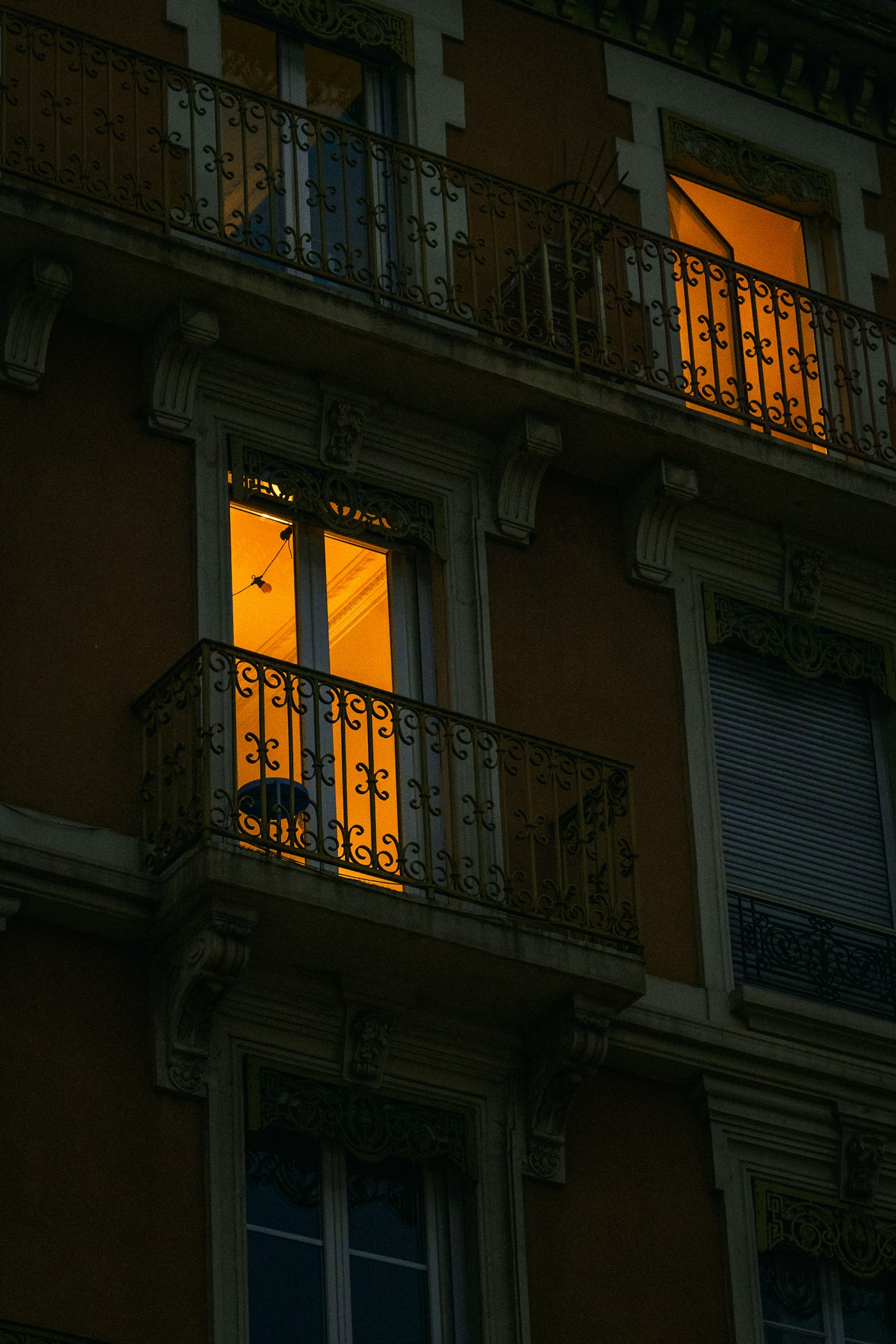 Wohngebäude mit warm beleuchtetem Fenster bei Nacht