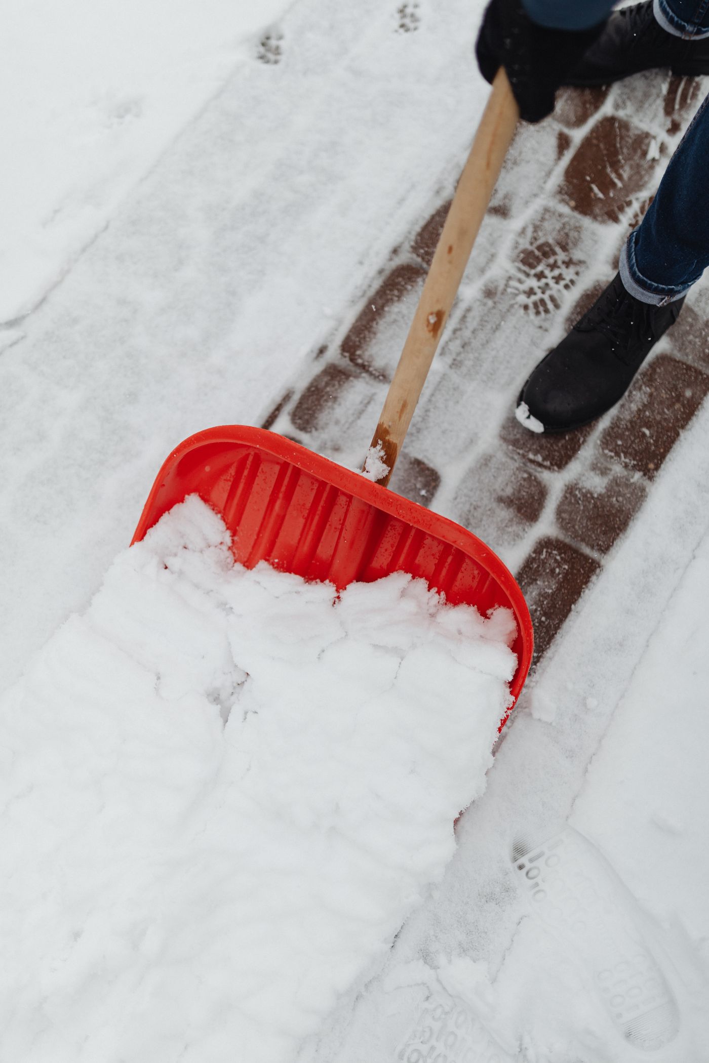 Räum- und Streudienst: Gehweg wird von Hand schneefrei gemacht